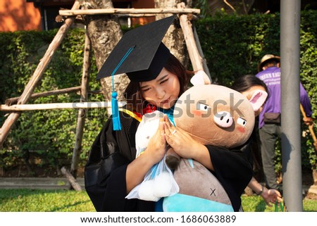 Thai women student wear graduation gown of Master Degree posing and portrait for take photo in commencement day of graduation ceremony in university at Nonthaburi city at Bangkok, Thailand