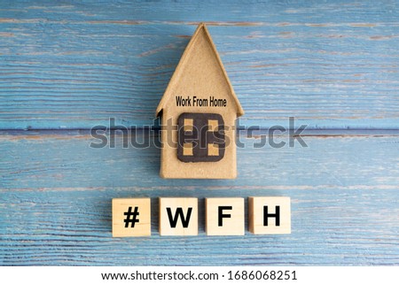 Concept image a wooden block and word - #WFH ( WORK FROM HOME ) on wooden background
