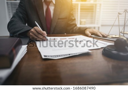 Middle-age of male lawyer working with legislation contract paper in courtroom, attorney justice and law concept.
