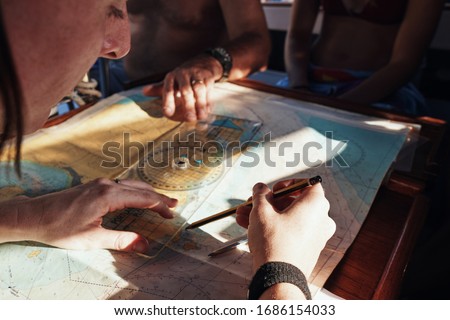 Student study RYA course with sailing map charts use Almanacs and Pilotage with chart reading and plotting by using protractors and dividers Nautical education Royalty-Free Stock Photo #1686154033