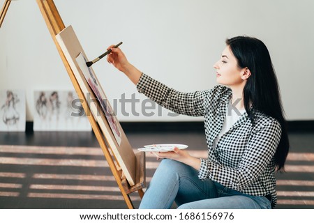Creative hobby and leisure concept. Young woman painting with watercolor at home studio