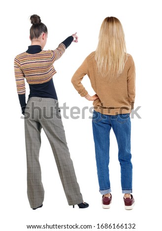 Back view of two pointing girl in sweater. Rear view people collection. backside view of person. beautiful woman showing gesture. Rear view. Isolated over white background.