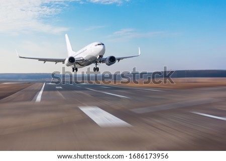 Runway at the airport and the plane flies and landing. Royalty-Free Stock Photo #1686173956