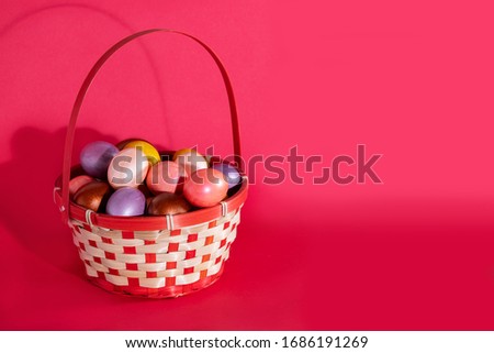 Easter painted eggs in basket isolated on red