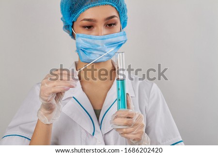 Portrait of young woman with swab and test tube. Experimenting and testing with chemical reactions. Isolated on white background.