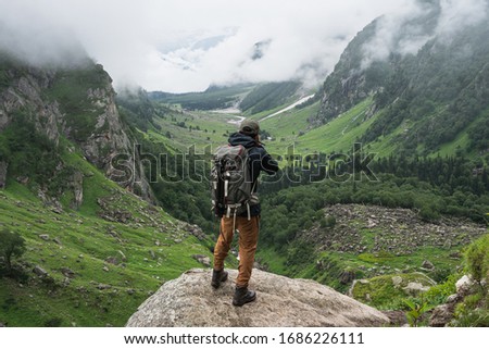 Photographer taking picture of mountain valley in summer season, Pin Bhaba pass trek in Shimla, north India, Asia