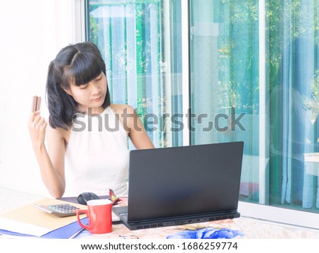 Work at home because covid-19 or corona virus with asian woman working document at home and Holding a chocolate.