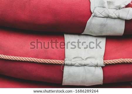 Abstract macro background of old red lifebuoys with white rope with copy space
