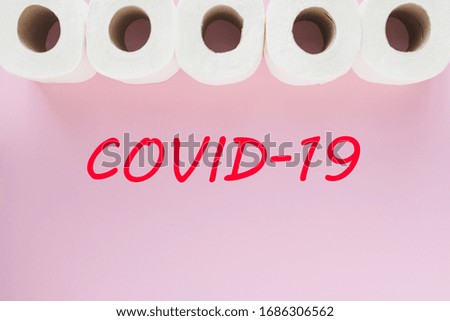 Coronavirus outbreak scene, showing toilet paper rolls on pink pastel backround, with Covid-19 sign below.  Minimal coronavirus concept.