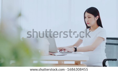 Asian pregnant women sit and work from home with happiness. By using the laptop to operate Planning meetings with business people from various locations. Or order online Concept social distancing