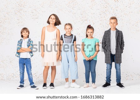 Group of happy children is standing together in a room