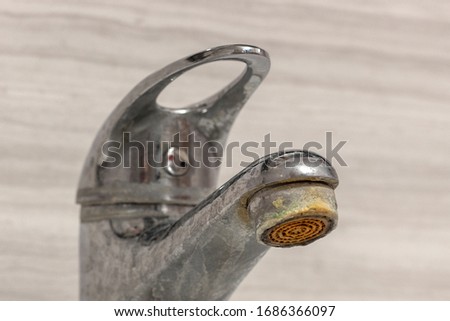 Old Bathroom Sink Faucet contaminated with calcium, grime and rust. Hard water stain build-up. Royalty-Free Stock Photo #1686366097
