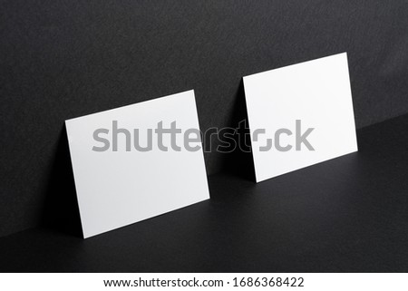 White businesscards on black background close up, copy space