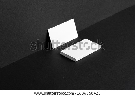 Stacked white businesscards for branding identity on black background, copy space Royalty-Free Stock Photo #1686368425