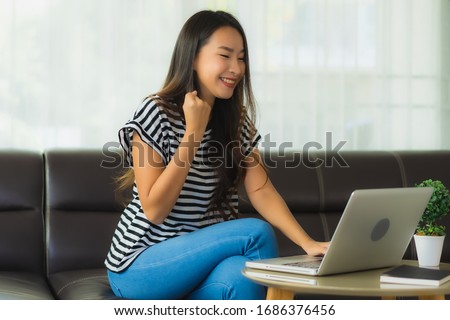 Portrait beautiful young asian woman using laptop or computer noterbook on sofa for save from coronaviruse or covid19