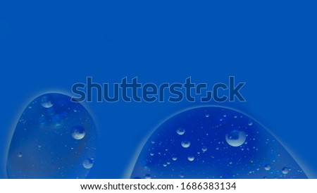 two drops on a blue background, close-up