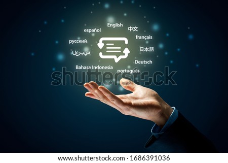 Translator professional and languages education concepts. Hand with symbol of translation (speech bubble with arrows and abstract text) and globally important languages. Royalty-Free Stock Photo #1686391036
