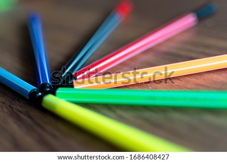 close-up colored marker pens lined up on a wooden background
