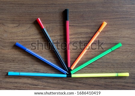 colored markers on a wooden background