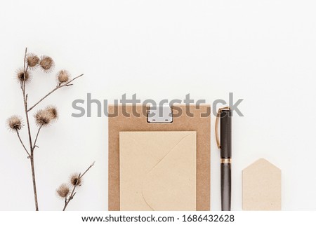 Notepad pen dry plant modern business background with copy space for your text. Top view, flat lay.
