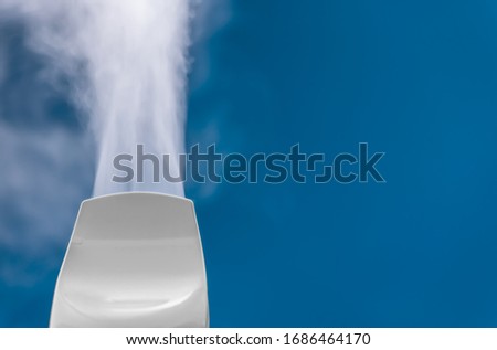 closeup steam from the air humidifier on blue background. health, disease prevention