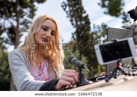 Female blond blogger interacting with her followers - working outdoors - traveling the world - bloggers and influencers work concept