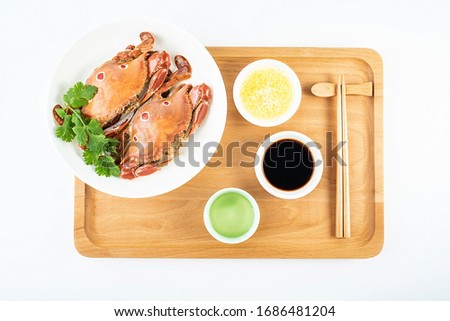 A dish of steamed three-pointed crab and dip in a white background	
