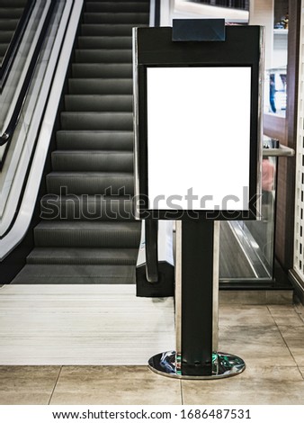 mockup of tall poster billboard roll up stand sign in shopping mall escalator representing advertisement of sales promotion discount on replacement blank canvas for graphic design overlay presentation