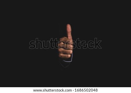 Businessman hand thumb up or like to good signal on black background.