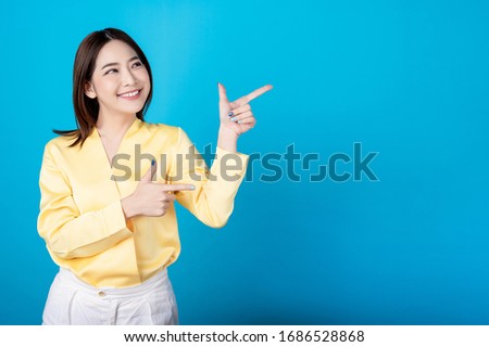 Beautiful young asian woman presenting point to copy space with big smile happy beaming face in seamless blue  isolated background. Presenter promotion, happy lifestyle, fresh pretty girl concept.
 Royalty-Free Stock Photo #1686528868