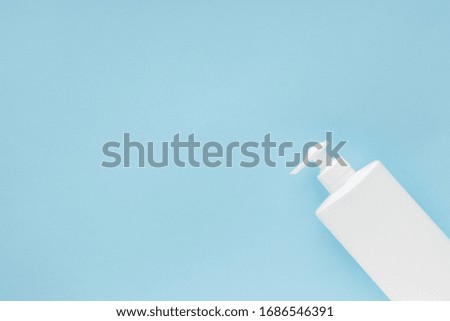 Alcoholic gel sanitizer bottle on light blue pastel background. Copy space on the left size for text. Coronavirus protection concept. 