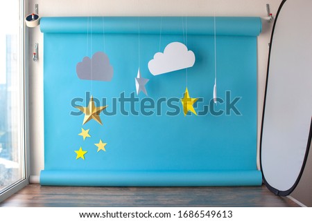 Paper background for birthday baby photoshoot. Blue sky and handmade paper cutting stars.