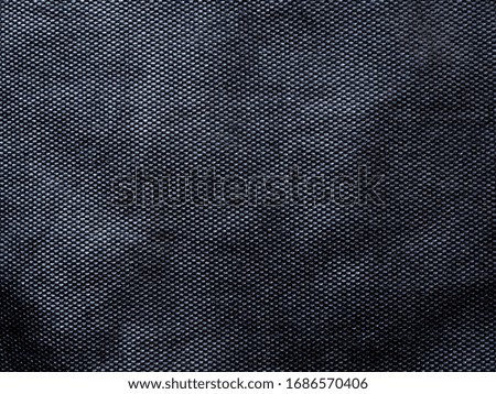 Abstract background texture of black mesh fabric.