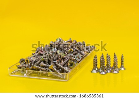 Metal Screws on yellow background. Close up stock photo.