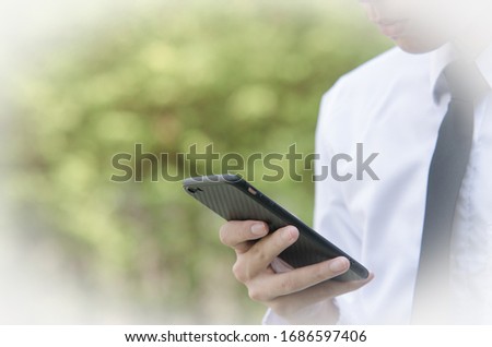 Close up of a business person using a smartphone, Working with smart phones in the park, technology concepts