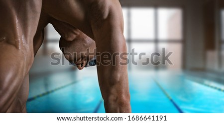 Swimming pool. Muscular swimmer ready to jump.	