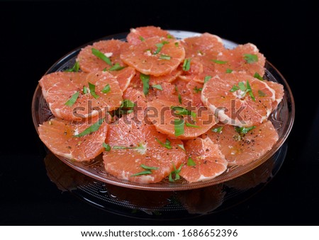 Food background. Cut fresh ripe grapefruit, top view, lay flat. Free space for text. Black background, mirror image