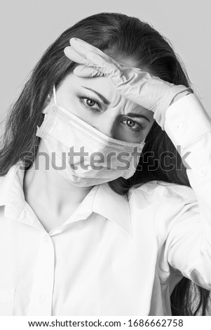 Woman in medical mask and gloves isolated on grey  background. Black and white photography with place for text