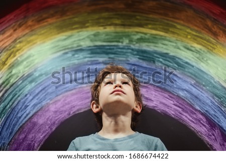 Chase the rainbow. child at home draws a rainbow on the wall. Children create artist paints creativity vacation. April 2 Autism Awareness Day. Misunderstanding Loneliness. Special another boy