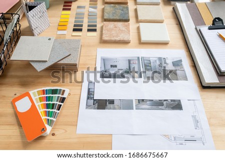Photographs of flat or house interior, samples of panels, color swatches and palette on wooden table where creative designer works
