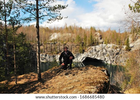 Man in Mountain park Ruskeala is tourist complex located in Sortavala region of Republic of Karelia Russia. Former marble quarry filled with groundwater. open cave in forest