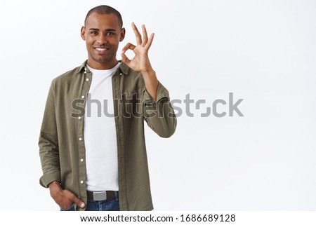 Good quality, guarantee you like it. Portrait of confident african-american man show okay, ok sign and smiling, nod in approval, give positive feedback, approve and agree, white background