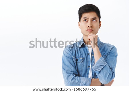 Portrait of thoughtful smart asian man thinking, male student solving puzzled, look up complicated or pondering, touch chin while trying made-up idea, daydreaming over white background Royalty-Free Stock Photo #1686697765