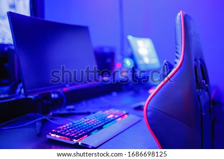 Gamer workspace professional streamer with computer monitor. Cyber sport championship, neon blue color lights.