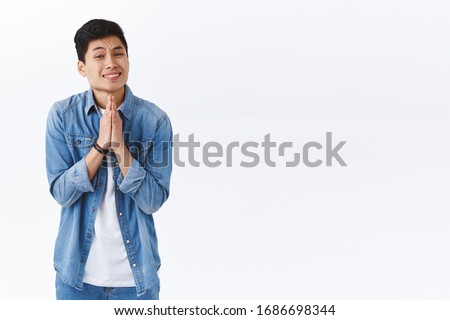 Portrait of clingy handsome asian guy need something asap, hold hands in pray, pleading or asking for help, begging person, grimacing standing white background supplicating Royalty-Free Stock Photo #1686698344