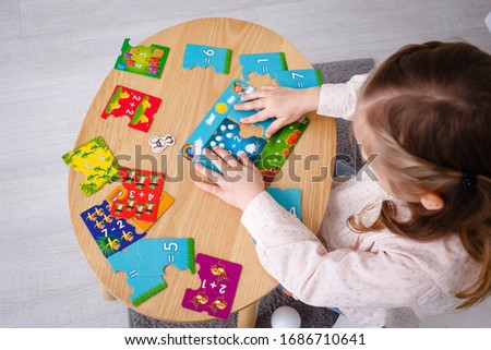 Girl solve math examples on the table game  Royalty-Free Stock Photo #1686710641