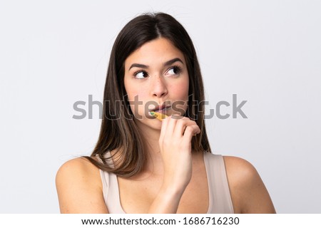 Teenager Brazilian girl brushing her teeth over isolated white background Royalty-Free Stock Photo #1686716230