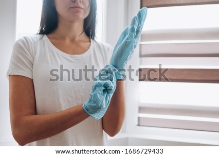 Woman in protective gloves. The concept of protection against coronavirus and hygiene.