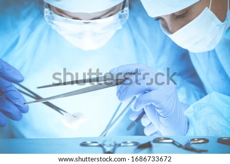 Close-up of medical team performing operation. Group of surgeons at work are busy of patient. Medicine, veterinary or healthcare concept