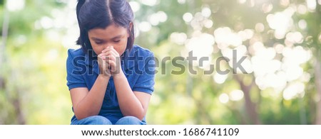Pray concept.Asian child praying,hope for peace and free from disease,Hand in hand together by kid ,believes and faith in christian religion at church-panoramic banner for web header